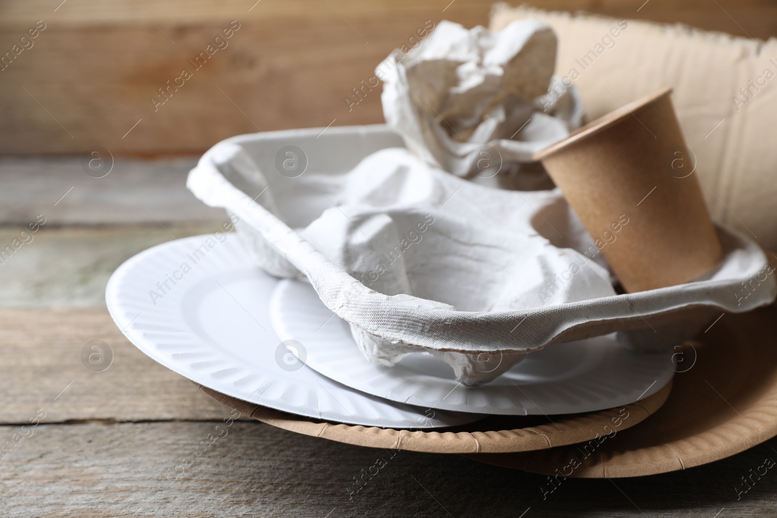 Photo of Different waste paper on wooden table, closeup