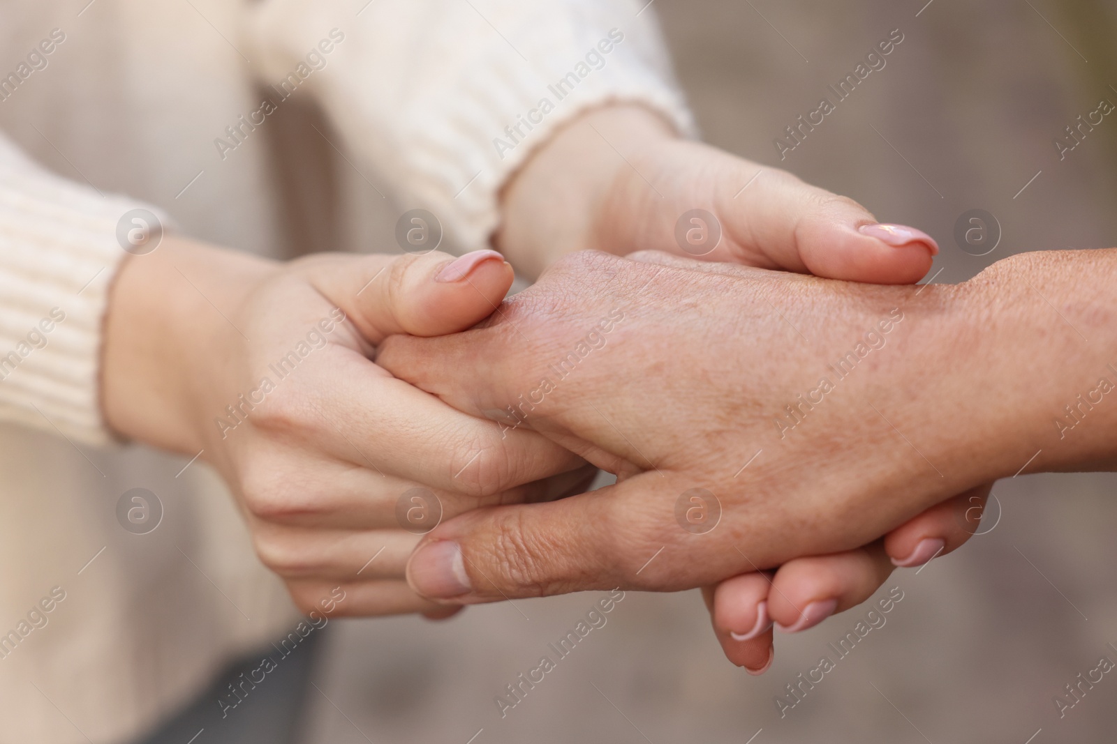 Photo of Trust and support. Women joining hands outdoors, closeup