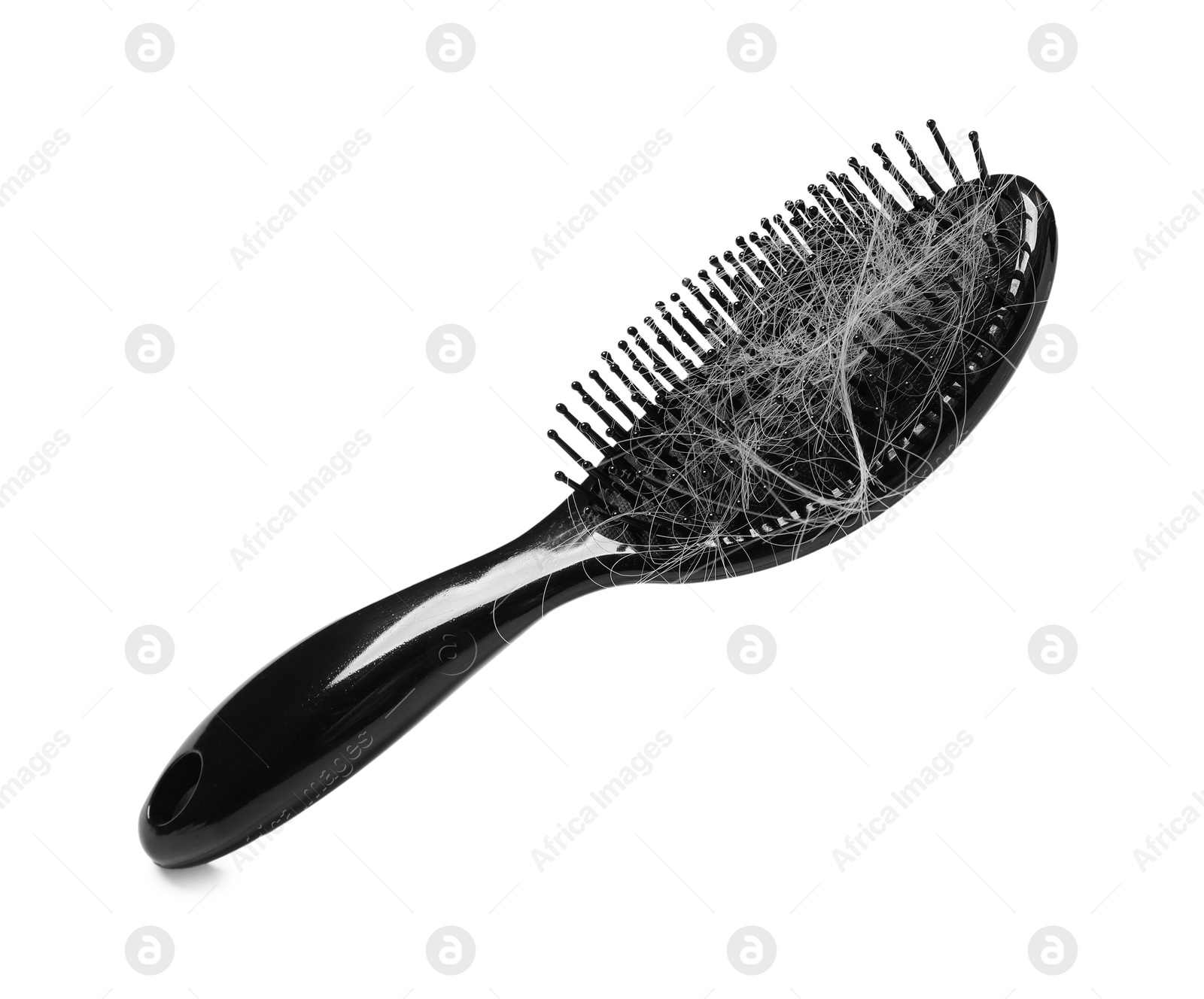 Photo of Brush with lost hair in air on white background