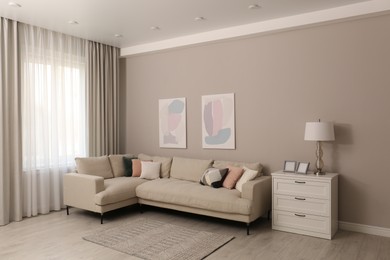 Photo of Stylish living room interior with modern comfortable sofa and pictures