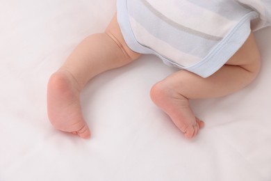 Photo of Newborn baby lying on white blanket, top view