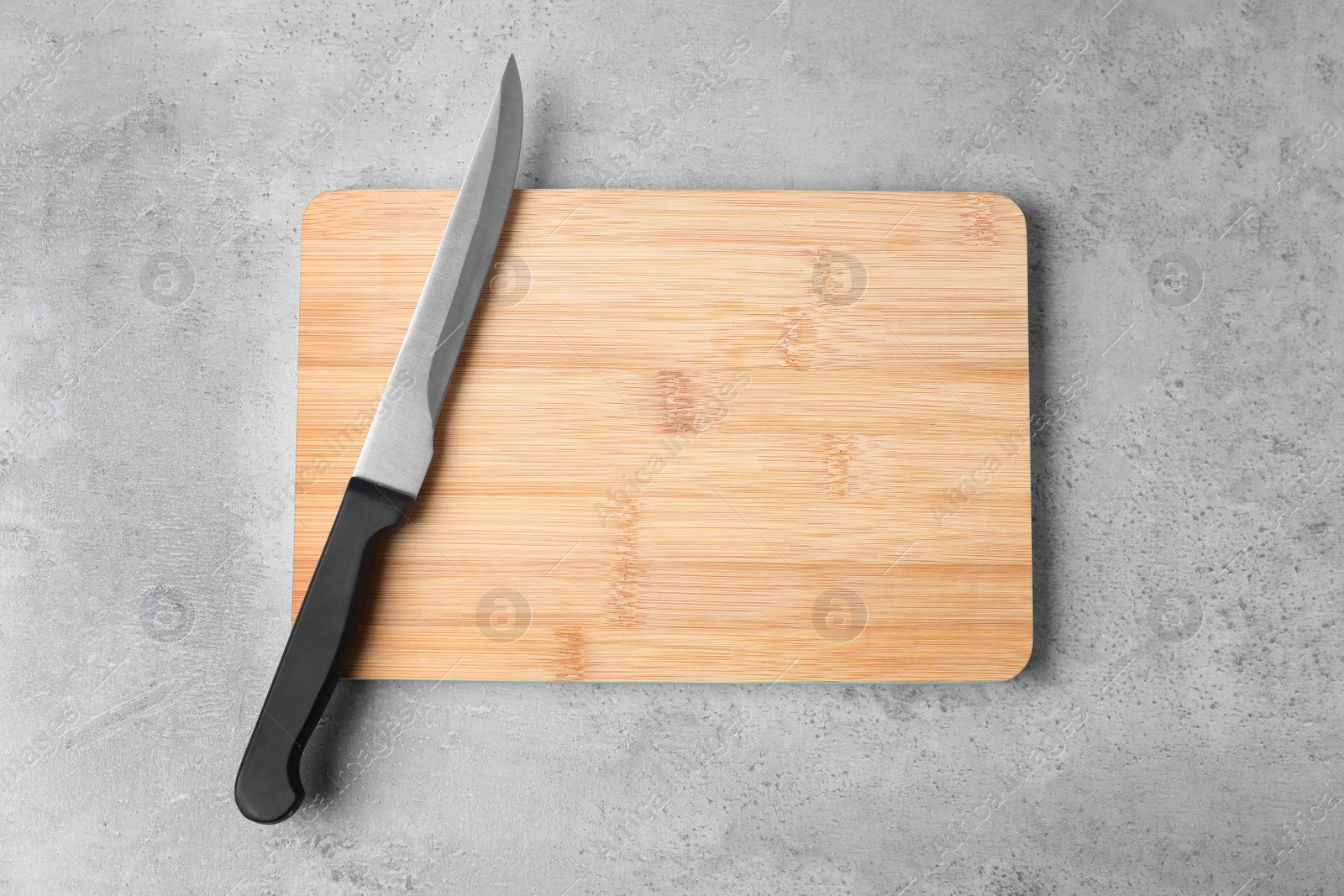 Photo of Cutting board with knife on grey background, flat lay. Space for text