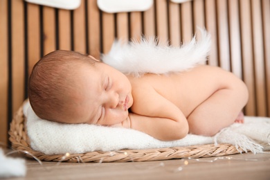 Photo of Cute newborn baby as Christmas angel in decorated studio