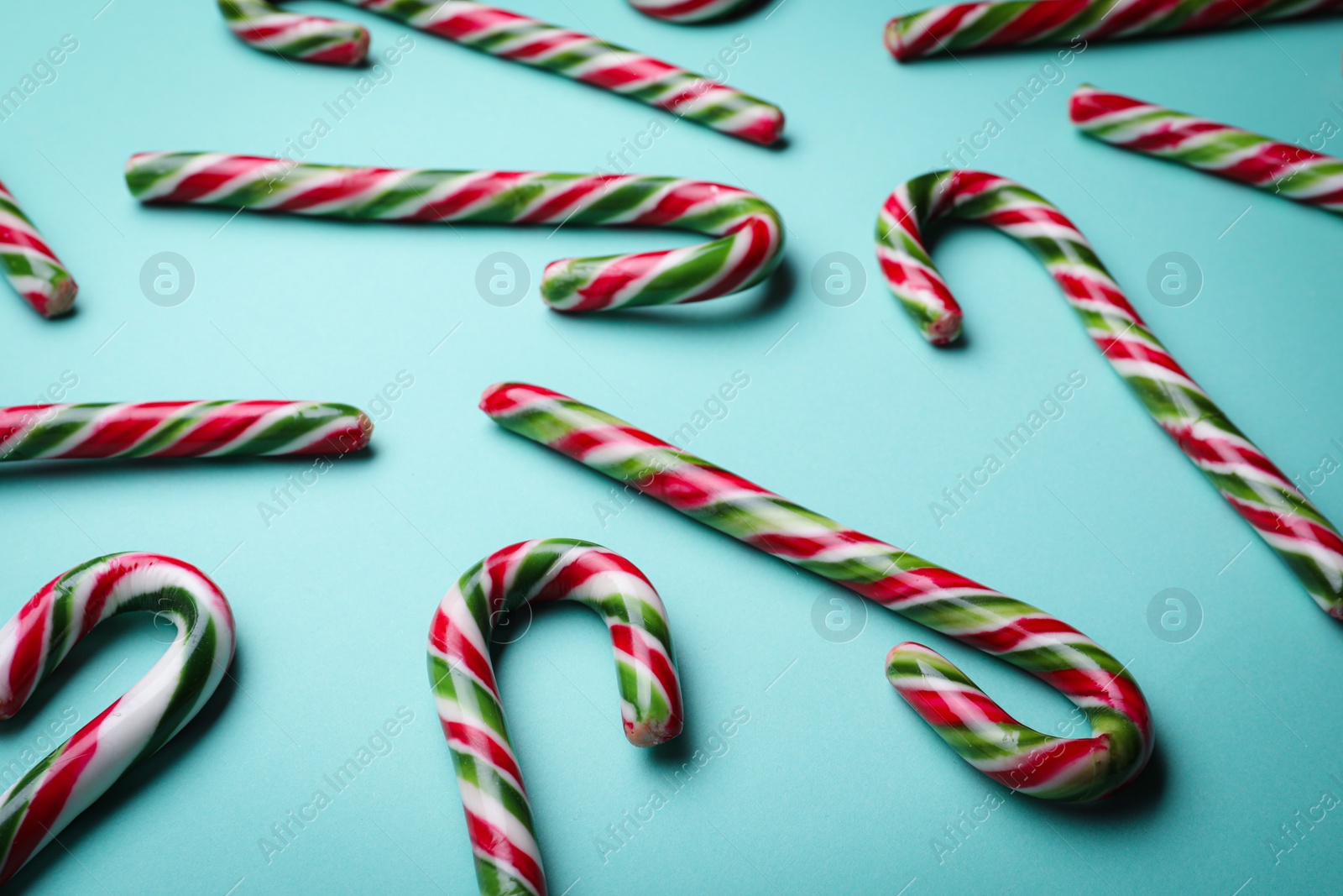 Photo of Many sweet Christmas candy canes on turquoise background