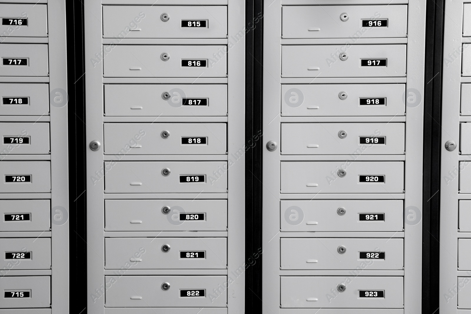 Photo of Closed metal mailboxes with keyholes and sequence numbers indoors