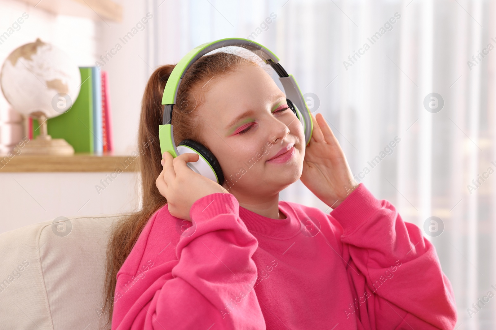 Photo of Cute indie girl in headphones listening music at home