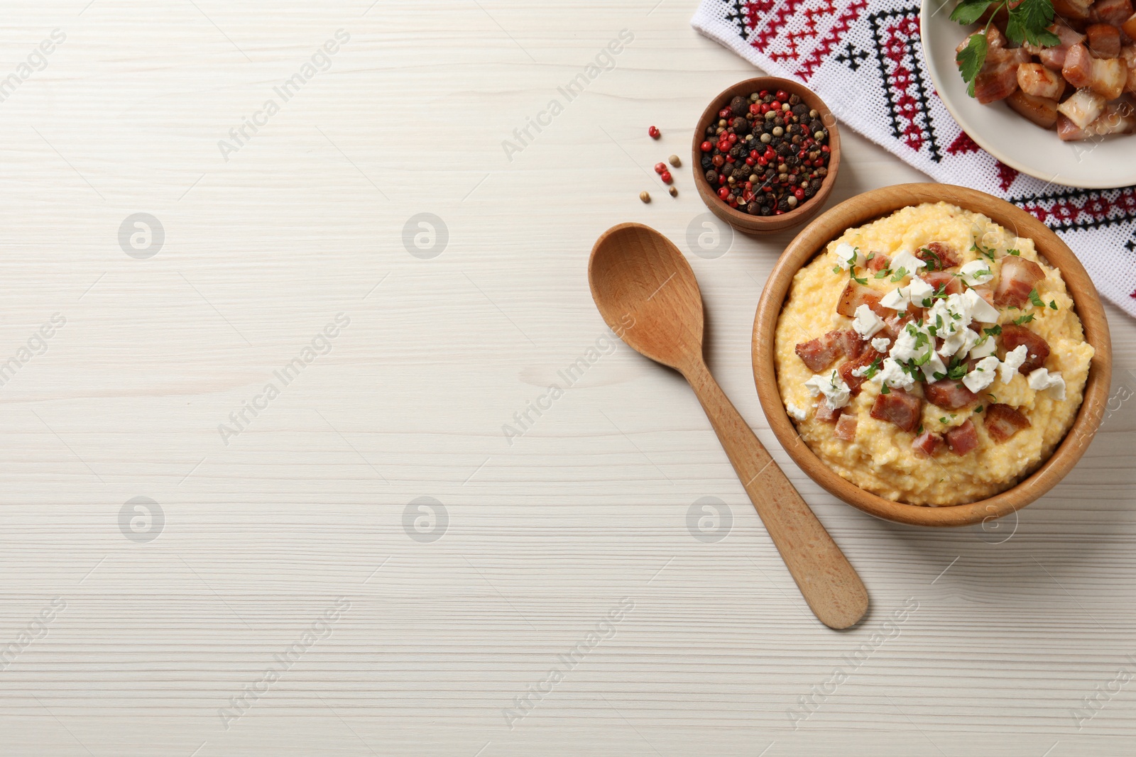 Photo of Delicious traditional Ukrainian banosh served on light wooden table, flat lay. Space for text