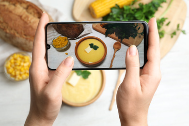 Blogger taking photo of dinner at table, closeup