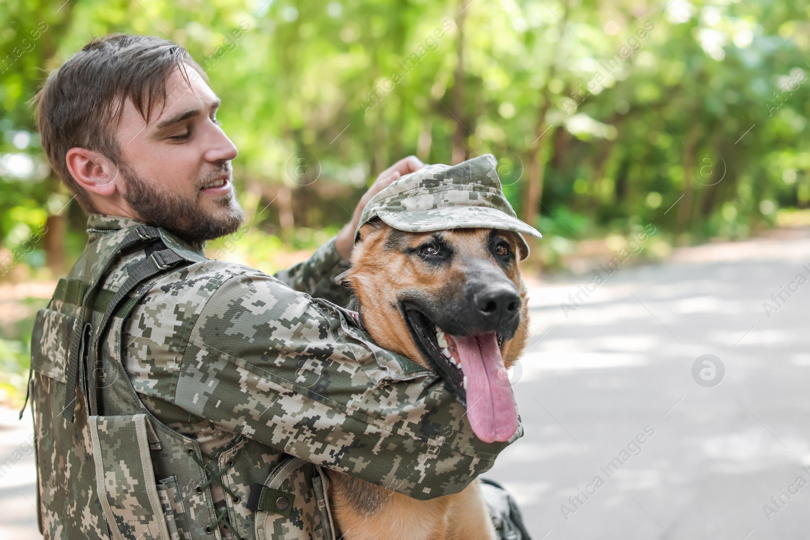 Photo of Man in military uniform with German shepherd dog outdoors