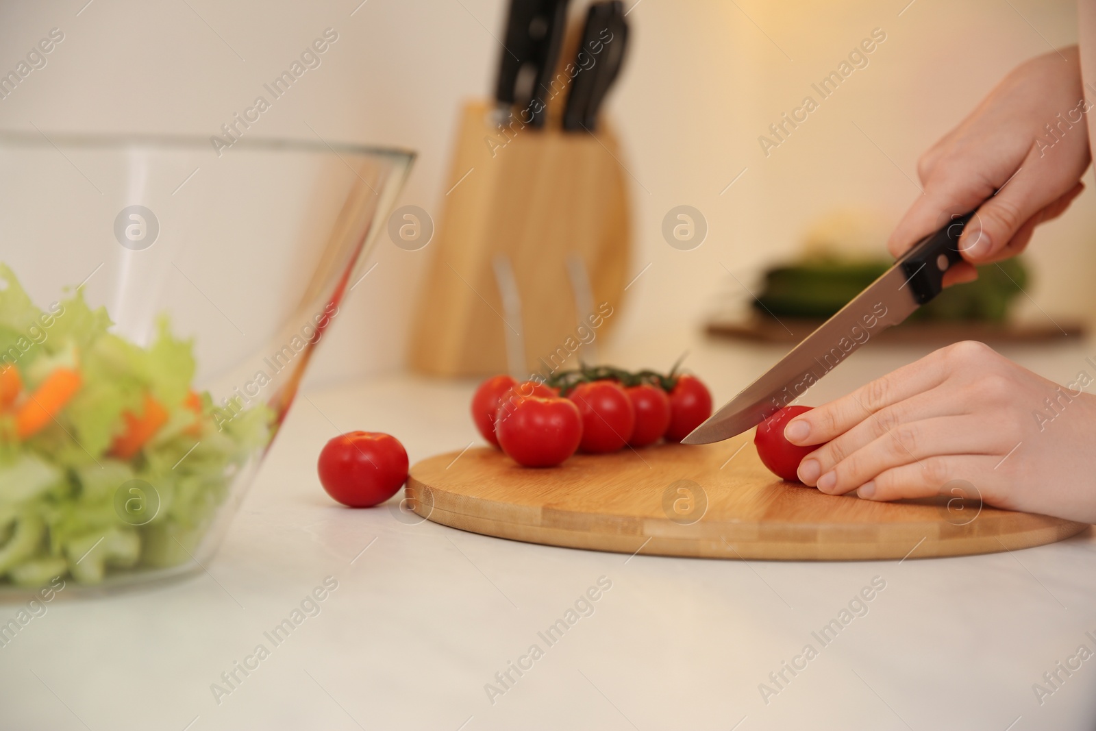 Photo of Young woman cooking at table in kitchen, closeup