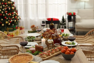 Photo of Festive dinner with delicious food and wine on table indoors. Christmas celebration