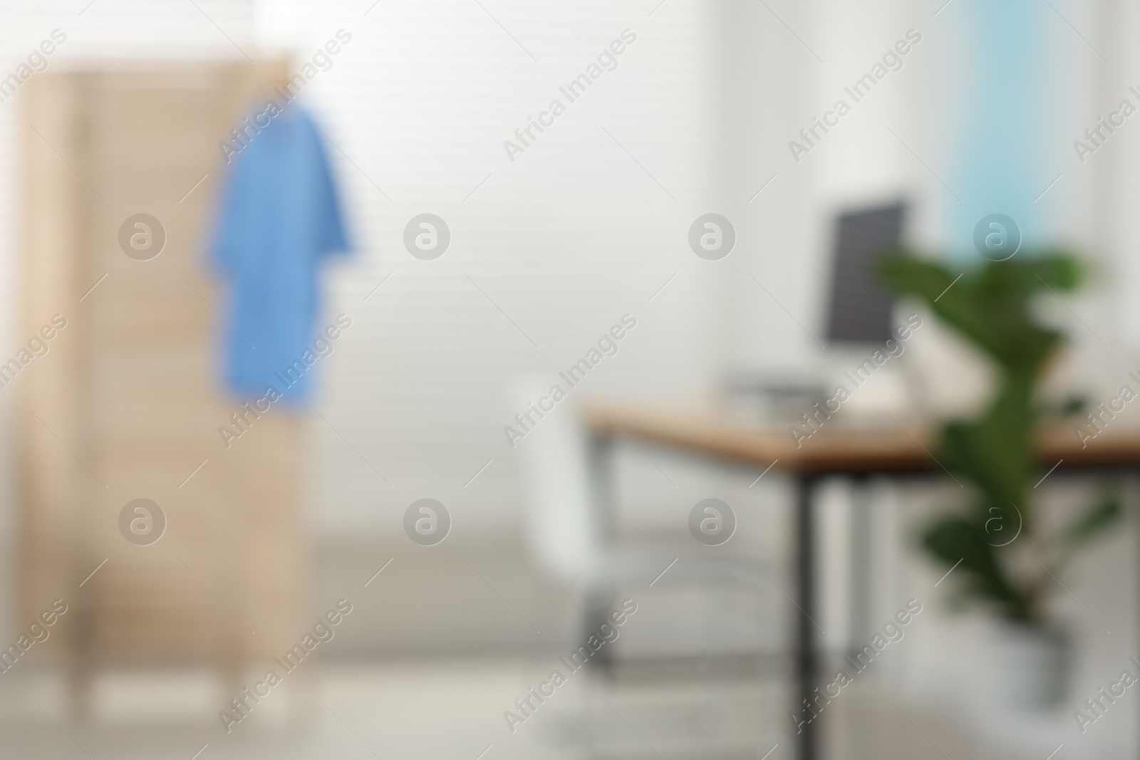 Photo of Blurred view of modern medical office with doctor's workplace in clinic