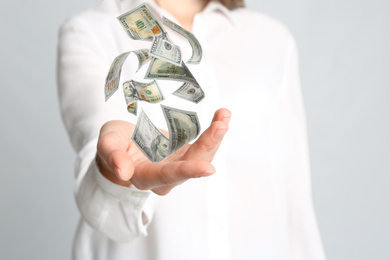 Woman with money on light grey background, closeup. Currency exchange