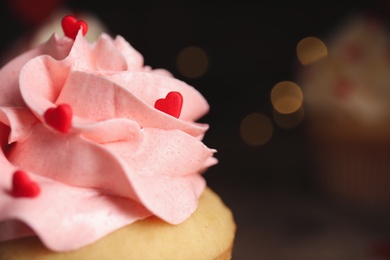 Photo of Tasty sweet cupcake on blurred background, closeup view with space for text. Happy Valentine's Day