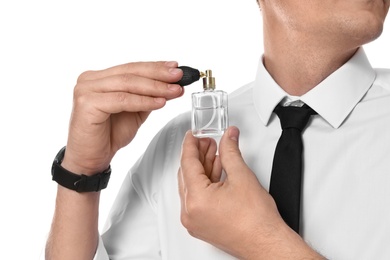Photo of Handsome man applying perfume on neck against white background, closeup