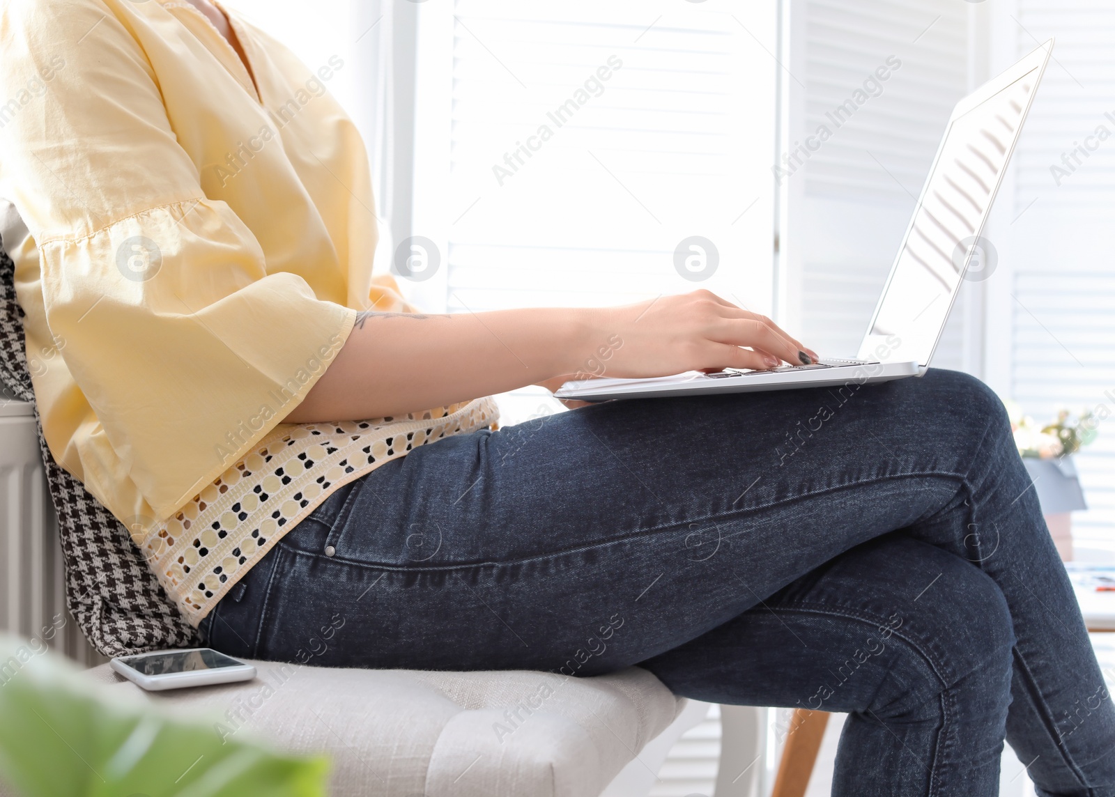 Photo of Young woman working with laptop at home