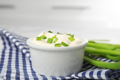 Photo of Fresh sour cream with onion on fabric, closeup