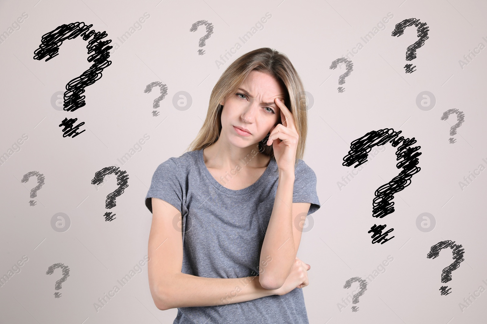 Image of Amnesia. Confused young woman and question marks on light background