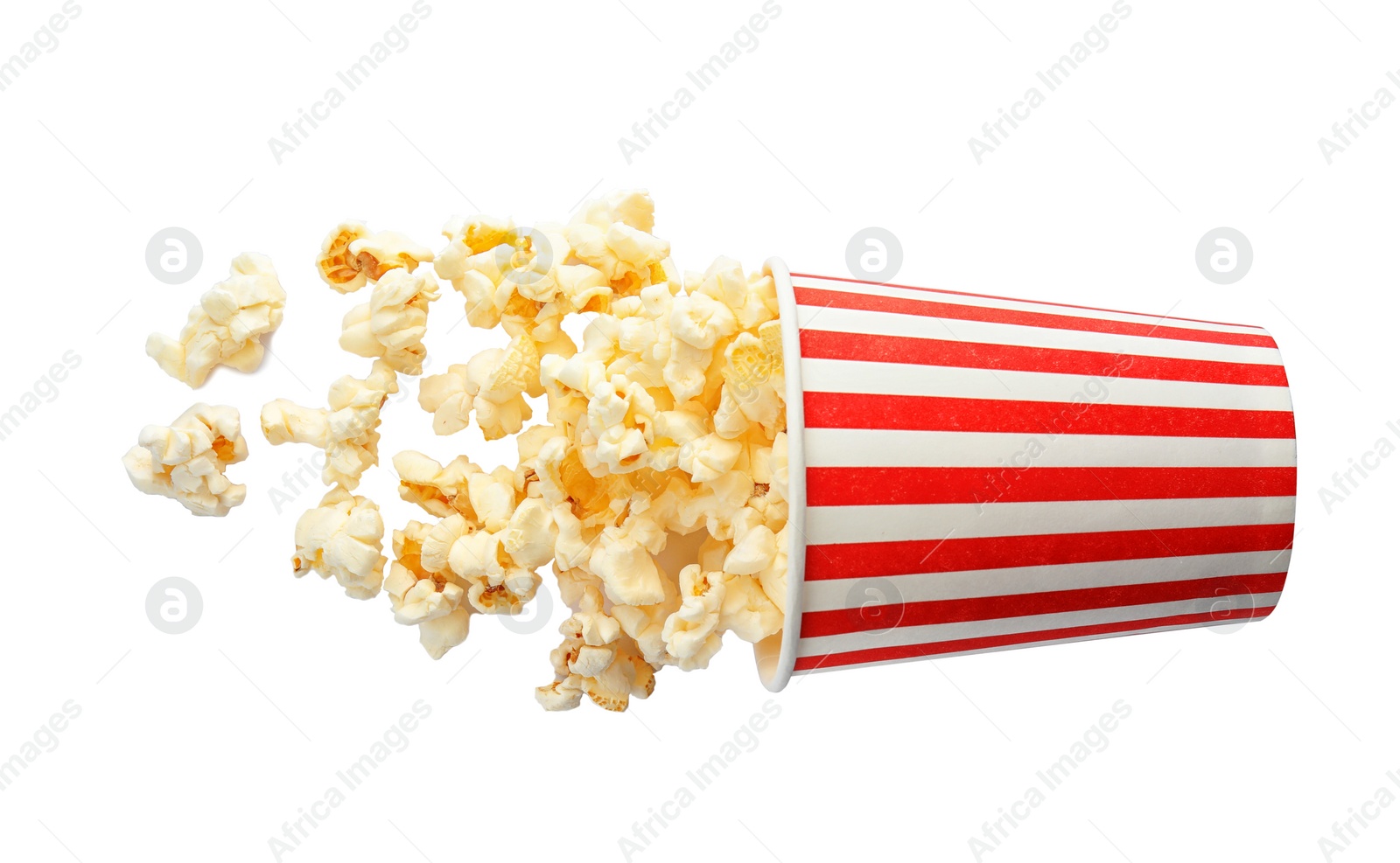 Photo of Overturned cup with delicious fresh popcorn on white background, top view