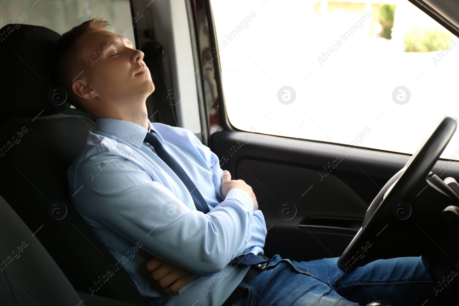 Photo of Tired young man sleeping in his modern car