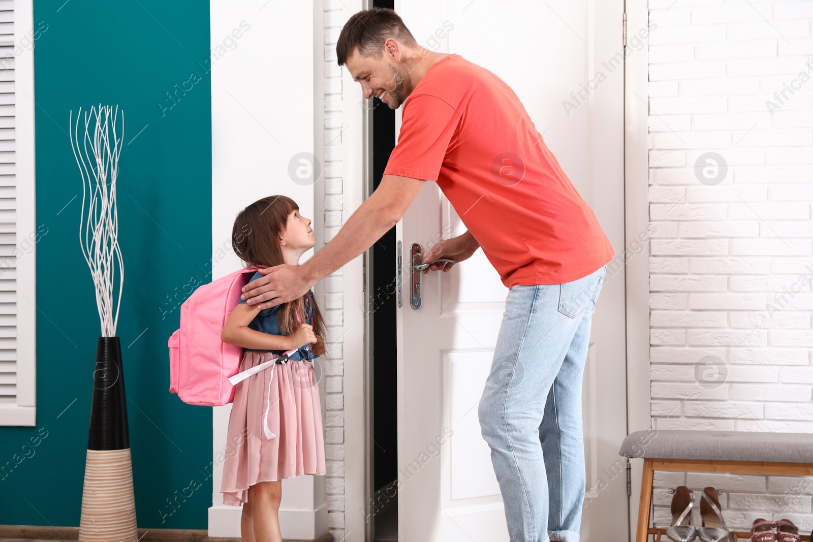 Photo of Happy father and little child with school bag in hallway