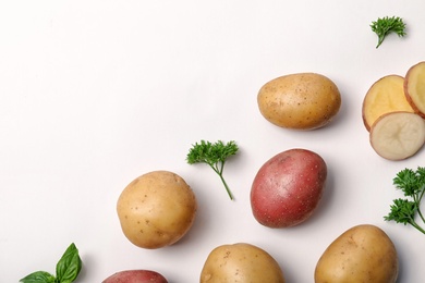 Flat lay composition with fresh organic potatoes and space for text on white background