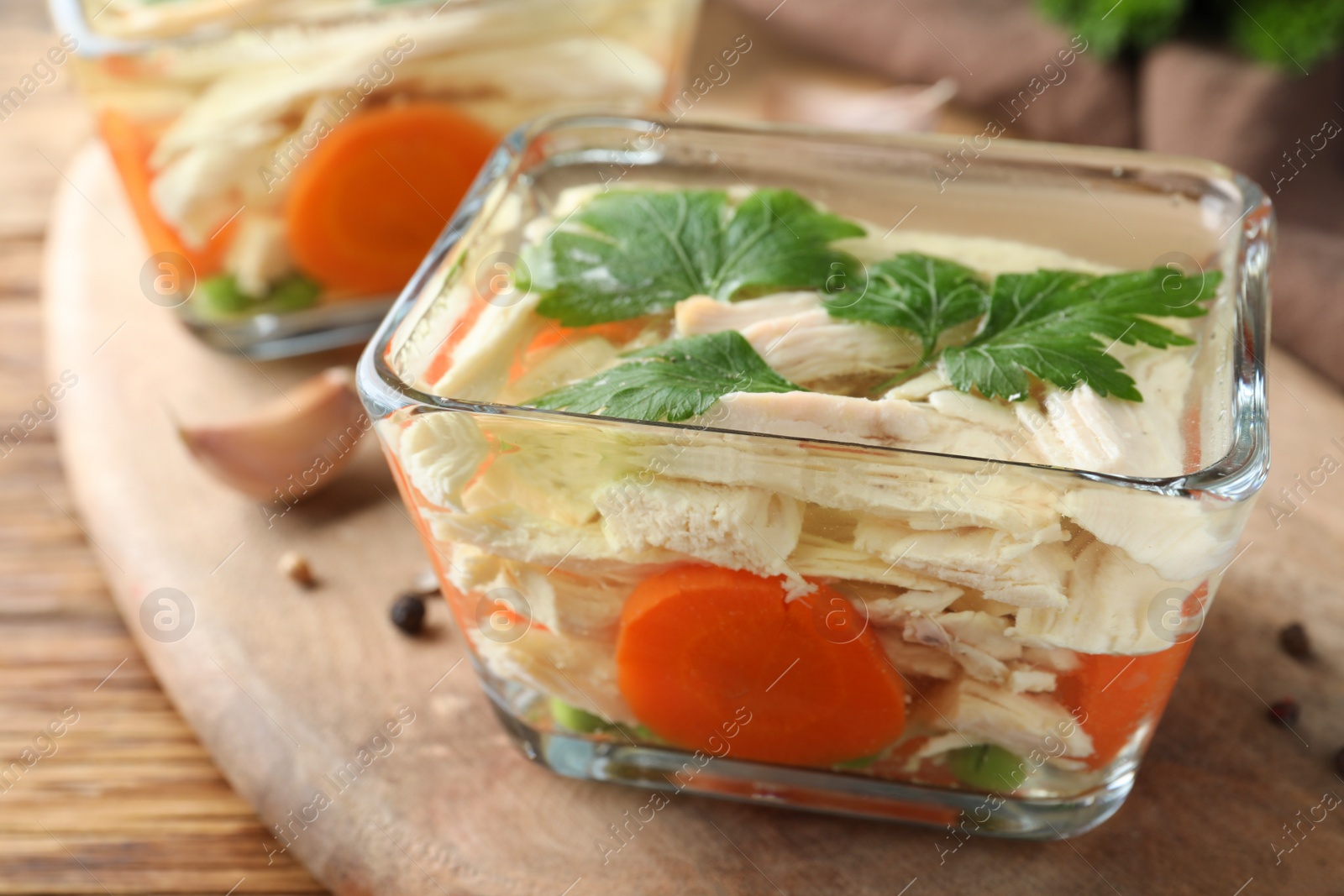 Photo of Delicious chicken aspic served on wooden board, closeup