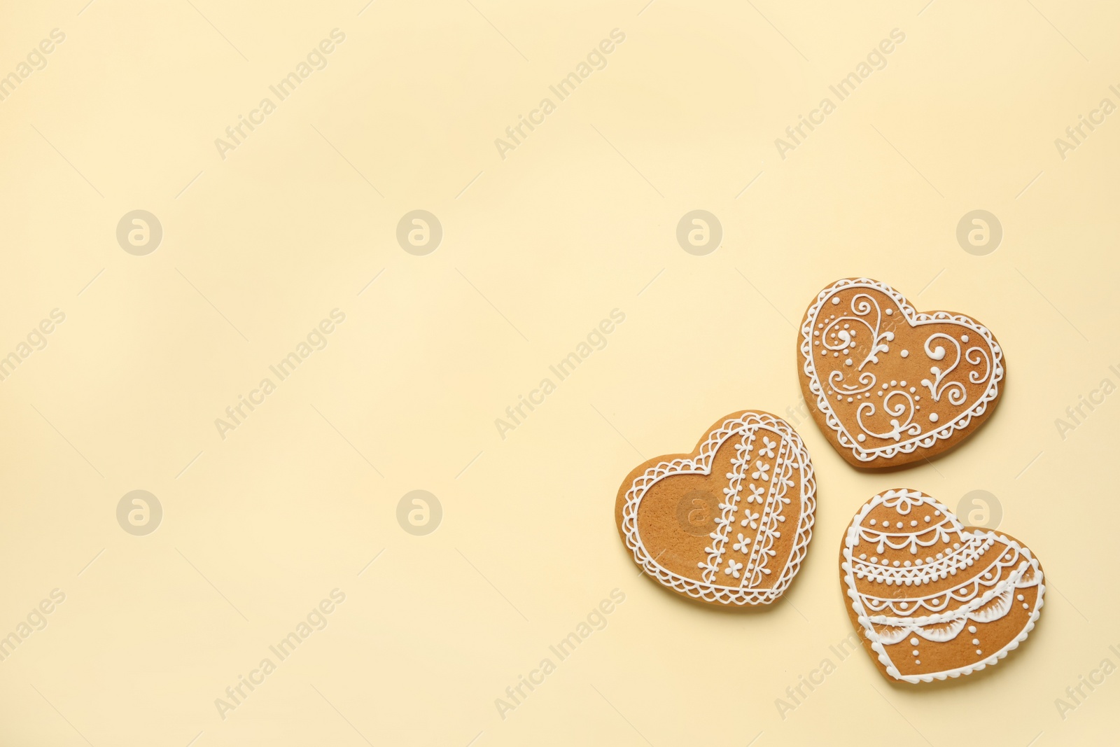 Photo of Tasty heart shaped gingerbread cookies on yellow background, flat lay. Space for text