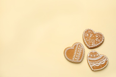 Photo of Tasty heart shaped gingerbread cookies on yellow background, flat lay. Space for text