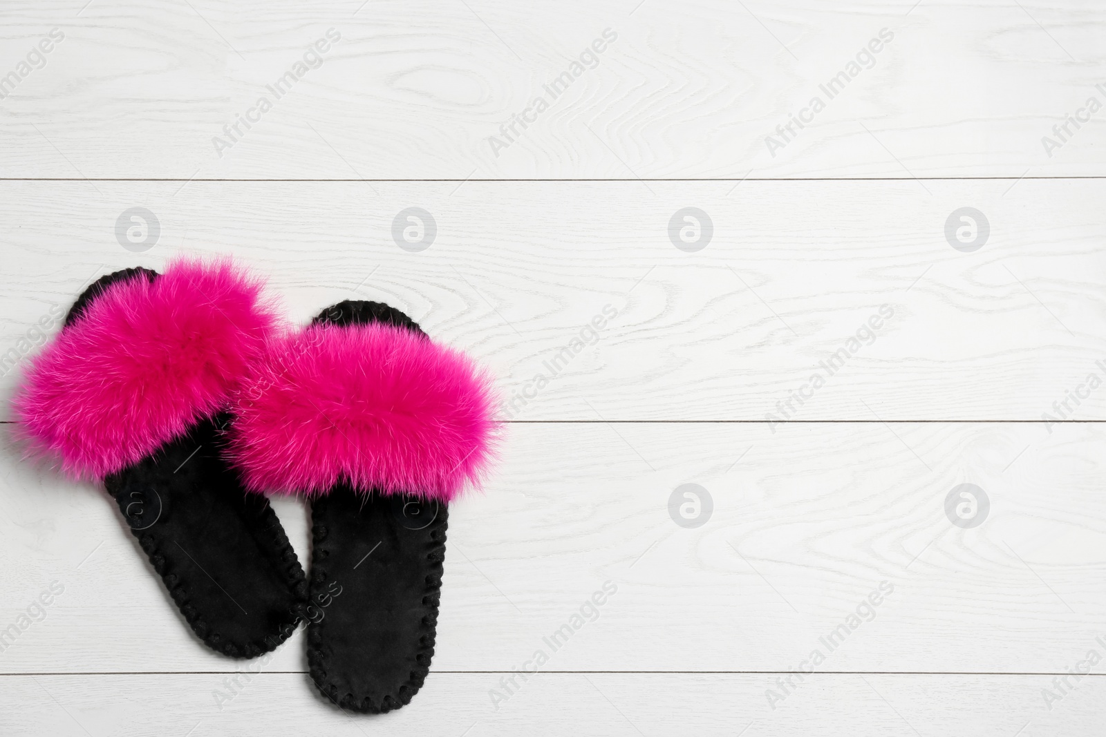 Photo of Pair of soft slippers on white wooden background, flat lay. Space for text