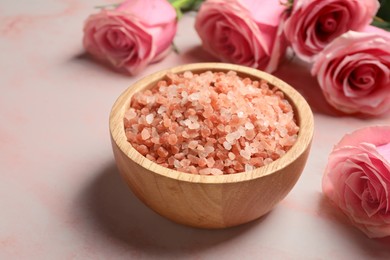 Photo of Aromatic sea salt and beautiful roses on pink marble table, closeup