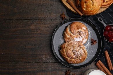 Photo of Delicious rolls with sugar powder, berries and spices on wooden table, flat lay with space for text. Sweet buns