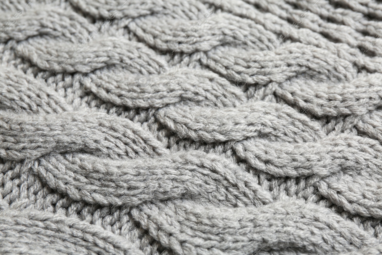 Photo of Grey knitted fabric with beautiful pattern as background, closeup