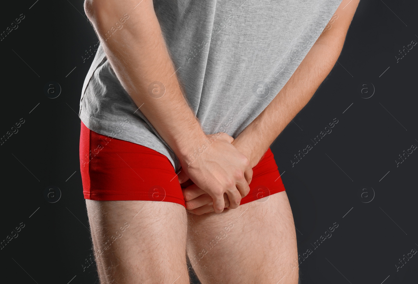 Photo of Man suffering from pain on black background, closeup. Urology problems