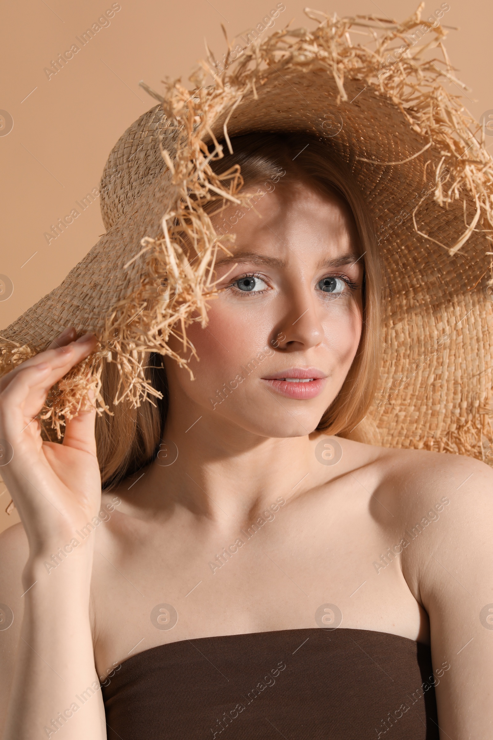 Photo of Beautiful young woman in straw hat on beige background