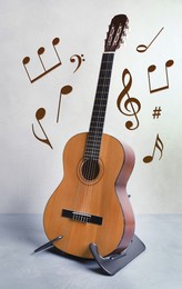 Image of Acoustic guitar, music notes and other musical symbols indoors