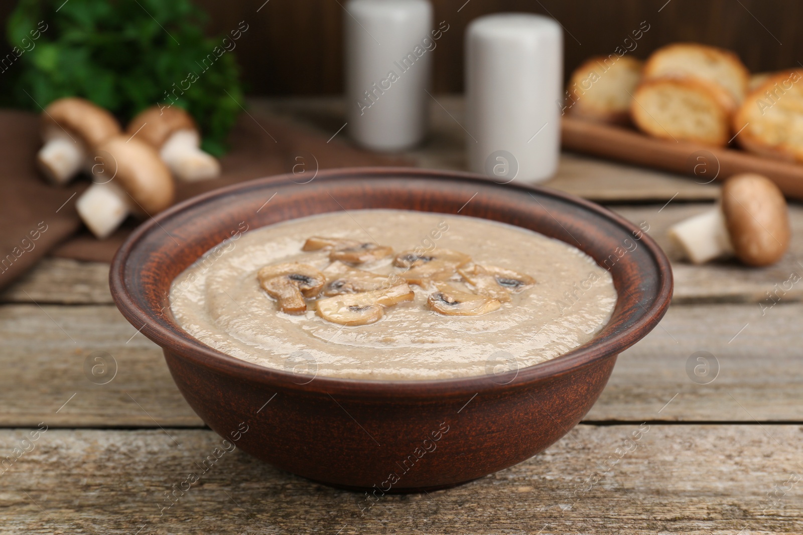 Photo of Delicious mushroom cream soup on wooden table