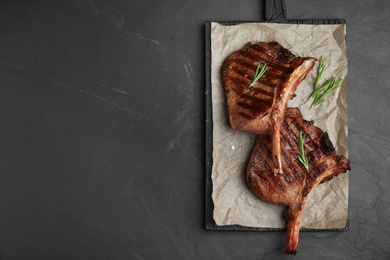 Photo of Delicious beef steaks on black table, top view. Space for text