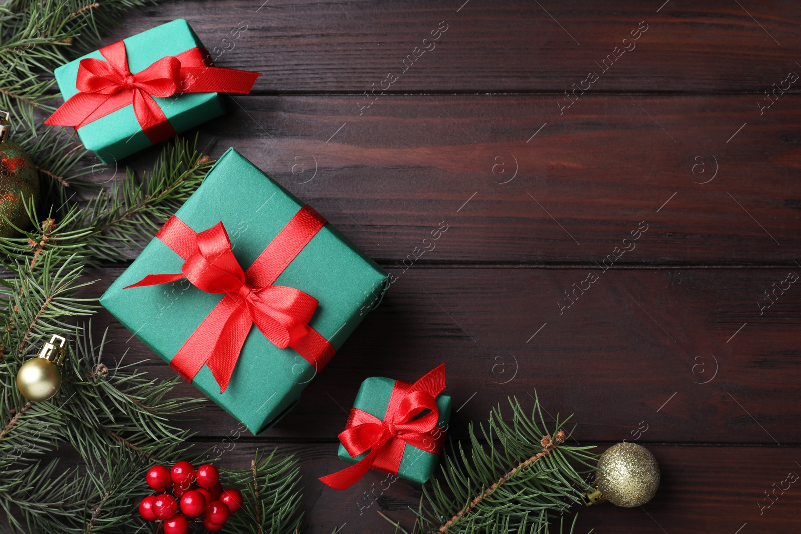 Photo of Flat lay composition with gift boxes and Christmas decorations on wooden table, space for text