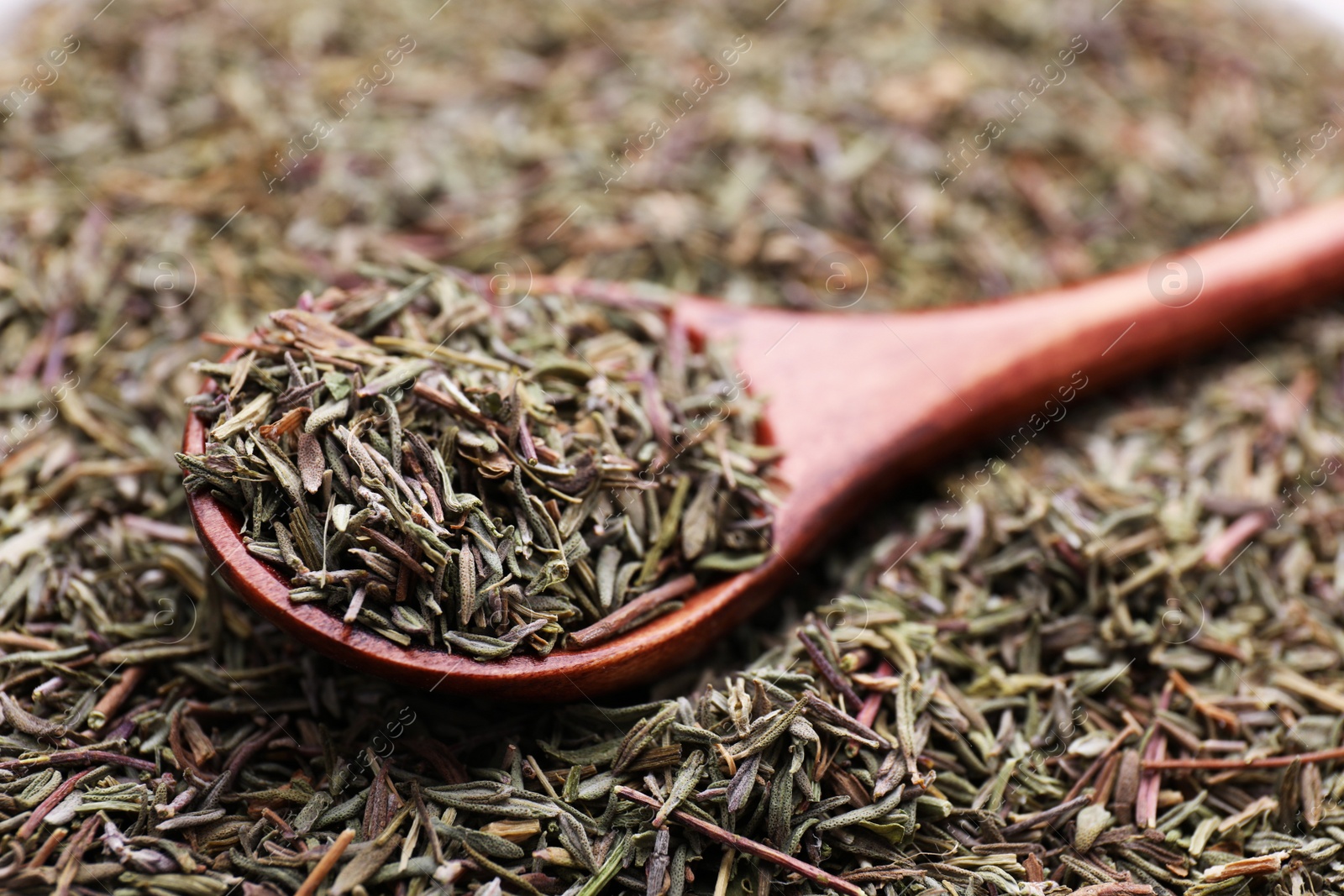 Photo of Wooden spoon with dried thyme, closeup view