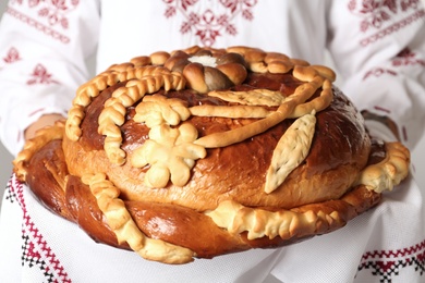 Photo of Woman with korovai, closeup. Ukrainian bread and salt welcoming tradition