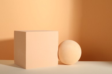 Photo of Presentation of product. Podiums and shadows on orange background. Space for text