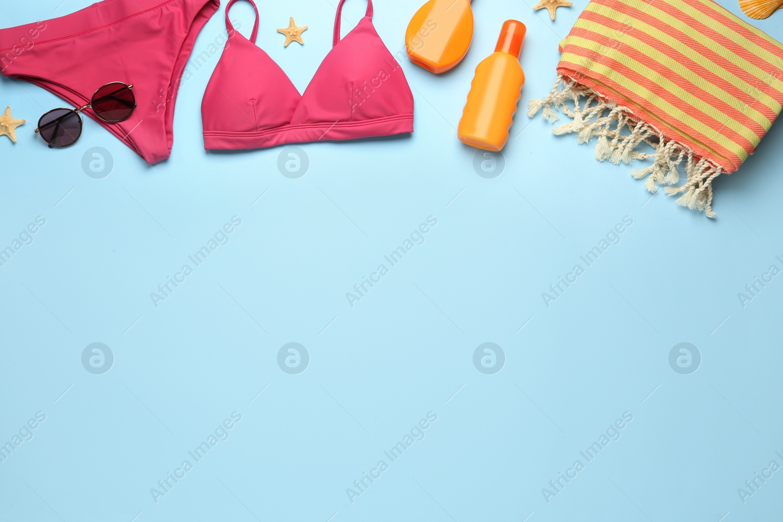 Photo of Flat lay composition with different beach objects on light blue background, space for text