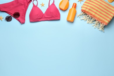 Flat lay composition with different beach objects on light blue background, space for text