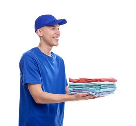 Photo of Dry-cleaning delivery. Happy courier holding folded clothes on white background