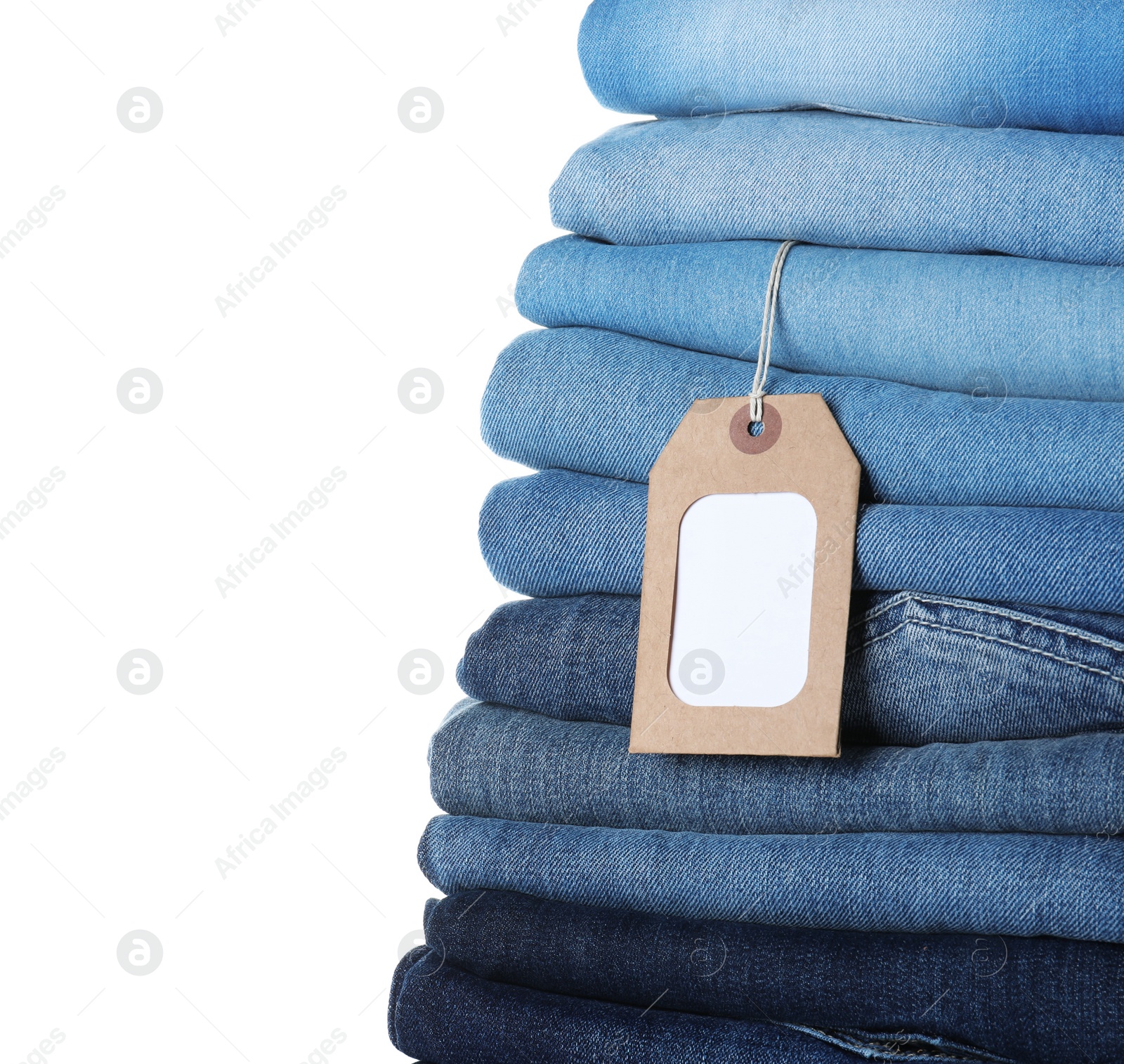 Photo of Stack of different jeans with tag isolated on white