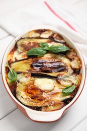 Photo of Delicious eggplant lasagna in baking dish on white wooden table