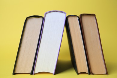 Photo of Collection of hardcover books on yellow background