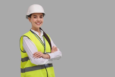 Engineer with hard hat on grey background, space for text