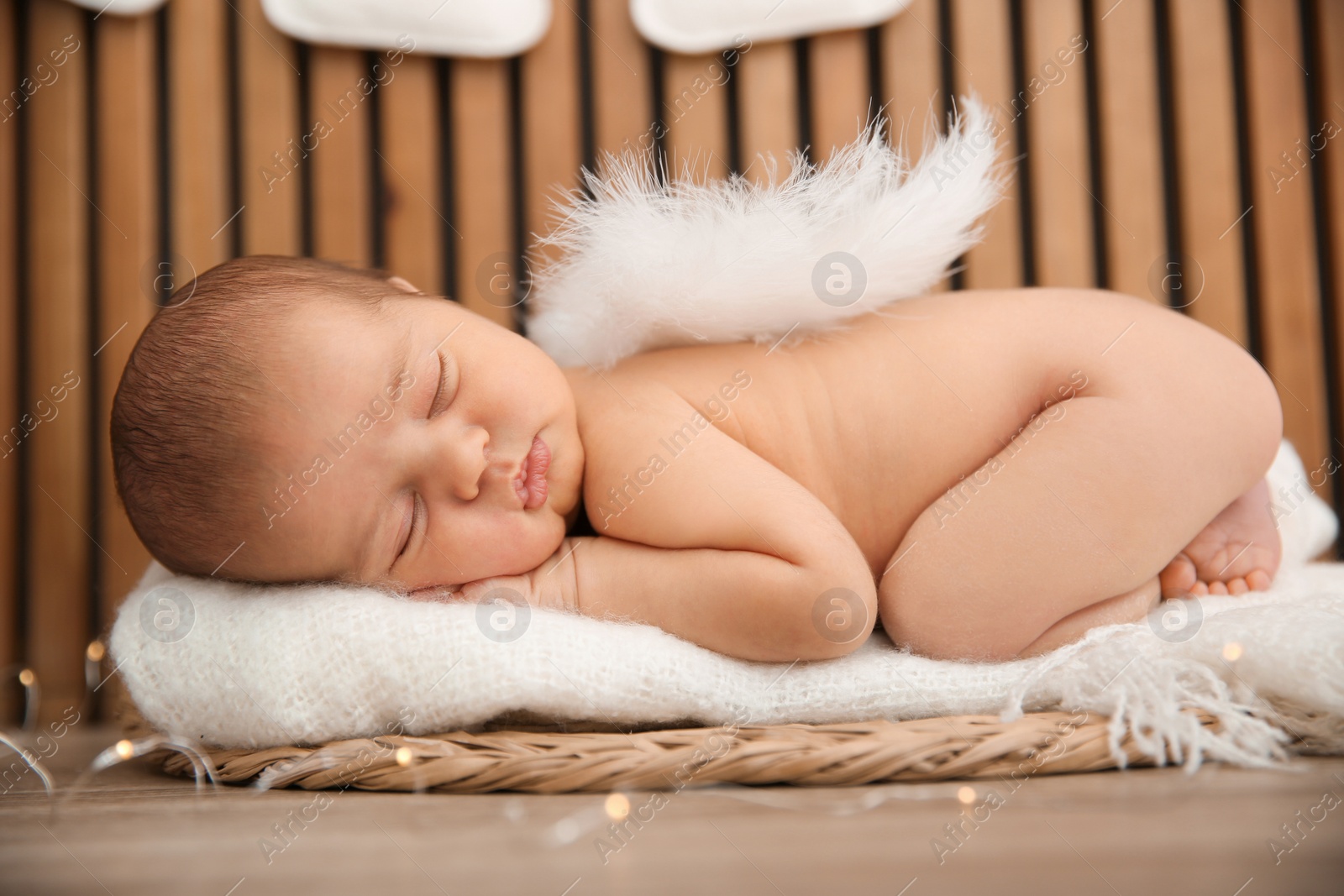 Photo of Cute newborn baby as Christmas angel in decorated studio